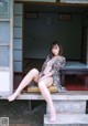 A woman sitting on a bench with her legs crossed.