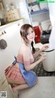 A woman in a blue and white apron is cleaning a kitchen.