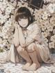 A woman sitting on a bed of white flowers.