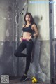 A woman in a black sports bra top and black leggings posing for a picture.