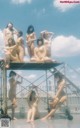 A group of naked women sitting on top of a building.