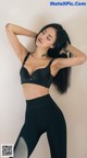 A woman in a black sports bra and leggings posing for a picture.