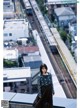 A woman standing on top of a building next to a train.