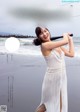 A woman in a white dress holding a baseball bat.