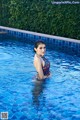 A woman in a bathing suit standing in a pool.